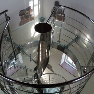 Helical spiral staircase with glass floor mirror finished stainless steel spiral stir with all glass stair treads and a feature helical centre column and a glass floor Helical spiral staircase with glass floor