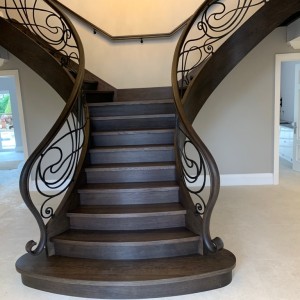 Bespoke Oak Y shaped curved staircase with hand forged iron balustrade. Closed rise oak treads Bespoke Oak Y shaped curved staircase with hand forged iron balustrade
