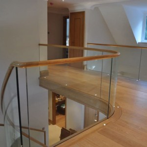 Contemporary frameless glass balustrade capped with oak handrails Contemporary frameless glass balustrade capped with oak handrails