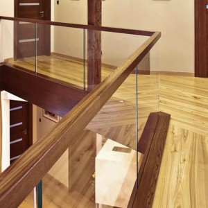 Glass balustrade for landing with inset no visible fixings and a feature walnut handrail and matching fascia Glass balustrade for landing with inset no visible fixings and a feature walnut handrail and matching fascia