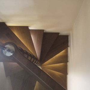 Spiral staircase with illuminated treads in a square style to match the square space Spiral staircase with illuminated treads in a square style to match the square space