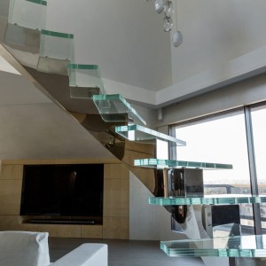 Central spine stair with polished stainless steel and glass treads Central spine stair with polished stainless steel and glass treads