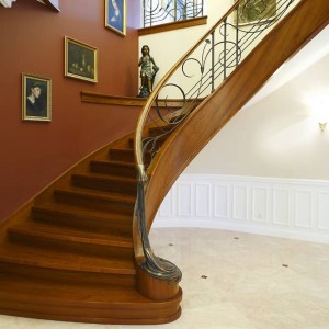 Curved feature staircase with bespoke iron balustrade stair in oak with feature solid bronze newel and bespoke iron balustrades inset with oak handrails Curved feature staircase with bespoke iron balustrade