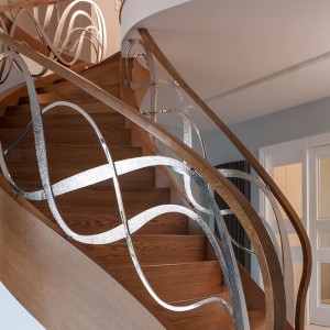 Helical oak staircase closed riser with feature hand forged iron balustrade Helical oak staircase closed riser with feature hand forged iron balustrade
