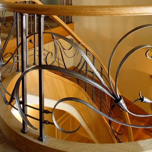 Hand forged iron feature balustrades with curved oak handrails Hand forged iron feature balustrades with curved oak handrails
