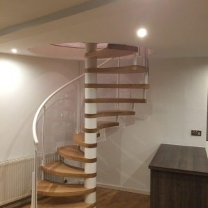 Spiral stair with petal shaped oak treads and an acrylic and steel balustrade Spiral stair with petal shaped oak treads and an acrylic and steel balustrade